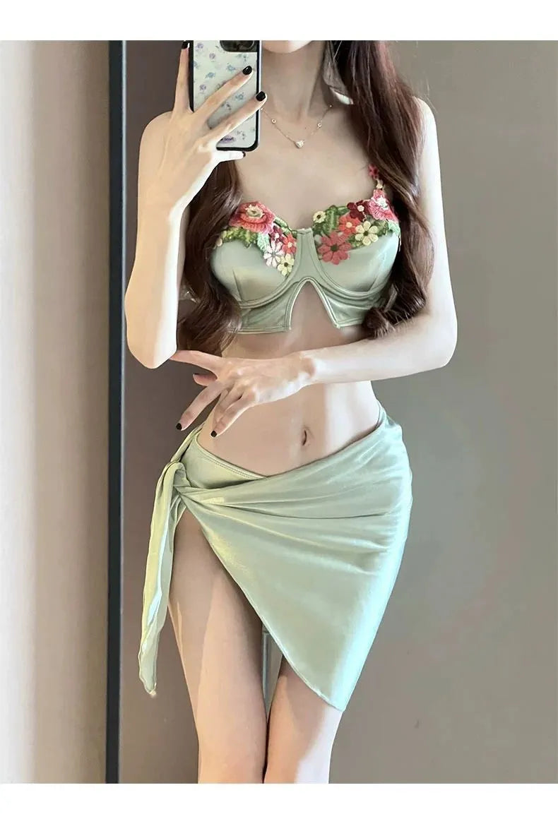 Green women's three-piece bikini set showing triangle top, briefs, and matching skirt on a white background.