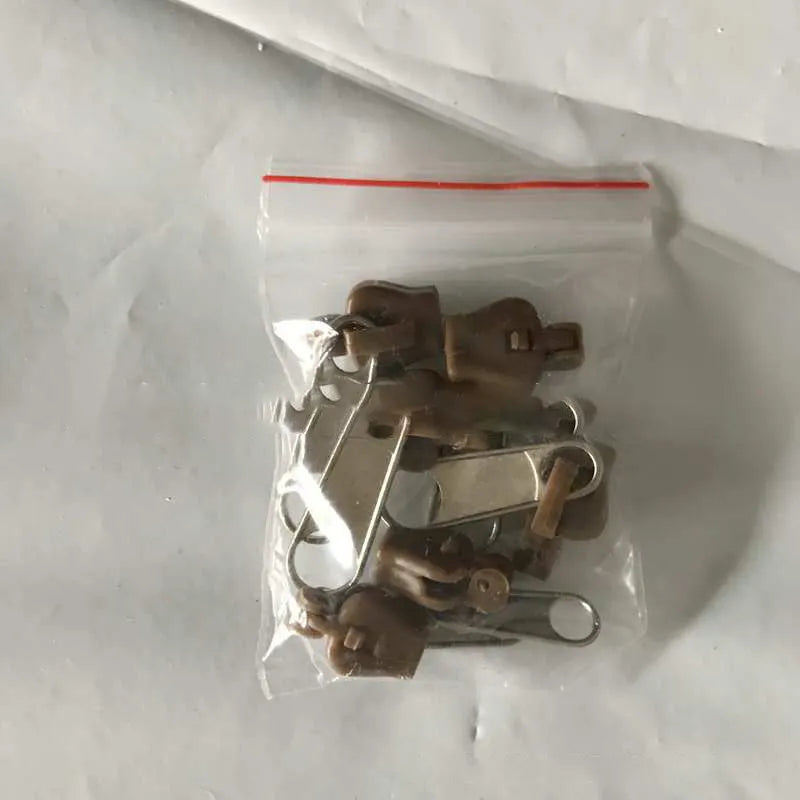 Plastic and metal zipper head replacement pieces in black, grey and brown colours