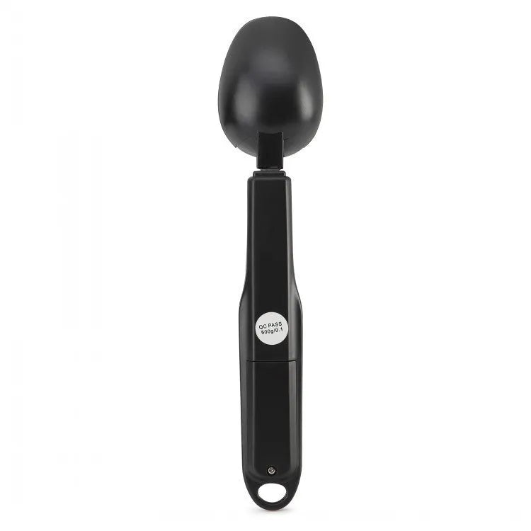 Digital smart measuring spoon with electronic display showing weight, placed on a kitchen worktop.