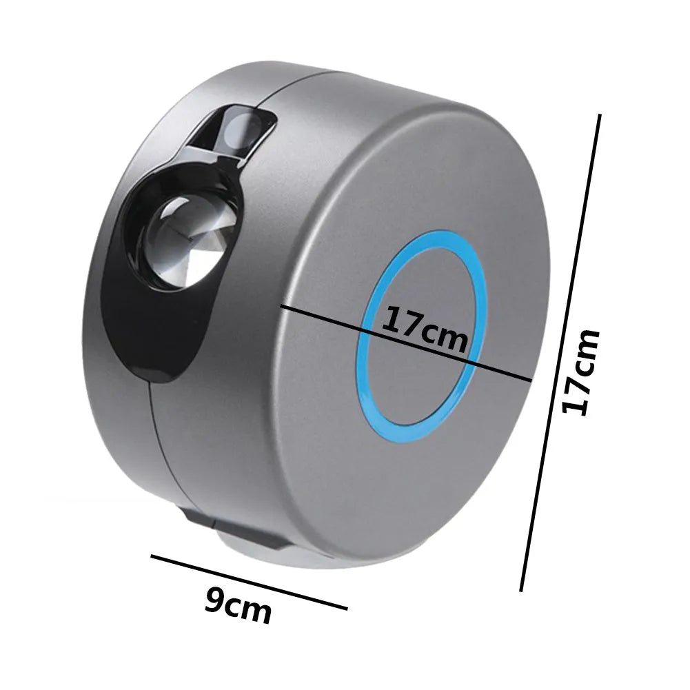 Grey starry sky projection lamp with remote control projecting coloured stars and green laser light indoors.