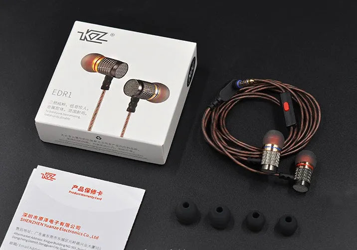 Close-up of wired in-ear headphones with metal subwoofer, TPE earplugs, and a 3.5mm L-bend plug on a silicone cable.