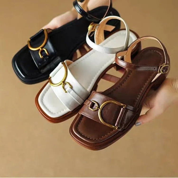Women's black leather sandals with a thick rubber sole and a single button closure on the strap.