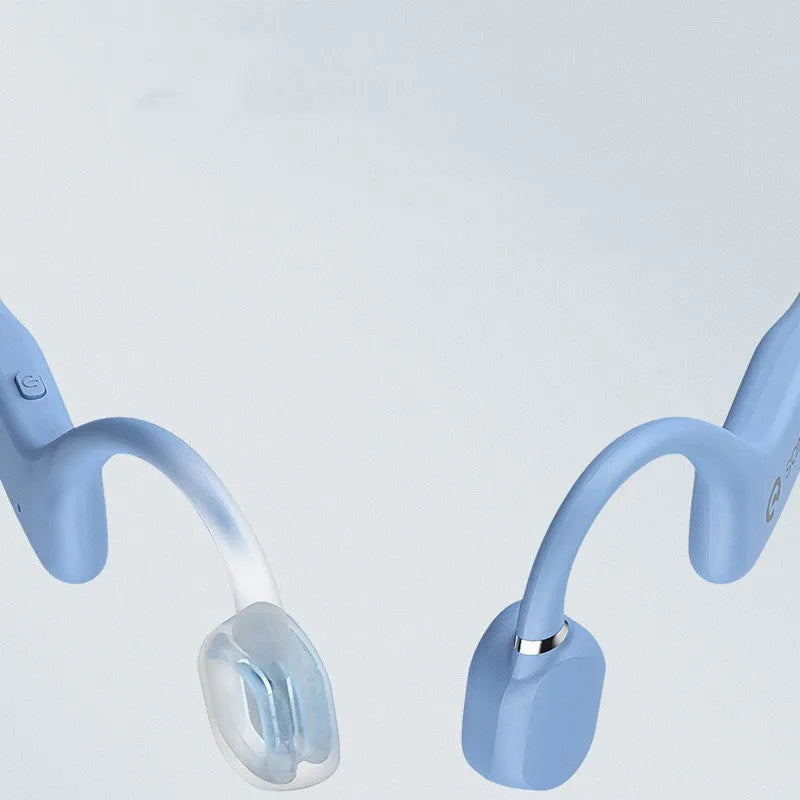 A person wearing black bone conduction Bluetooth headphones around their neck during a run.