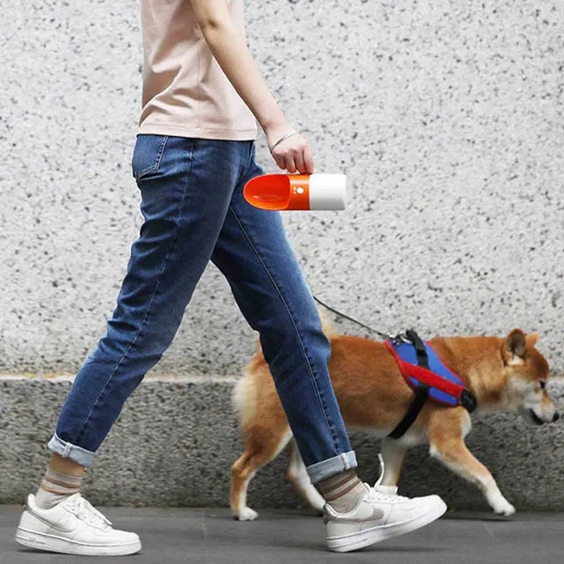 Moestar rocket-shaped pet drinking cup in white with grey accents showing water outlet and lock button