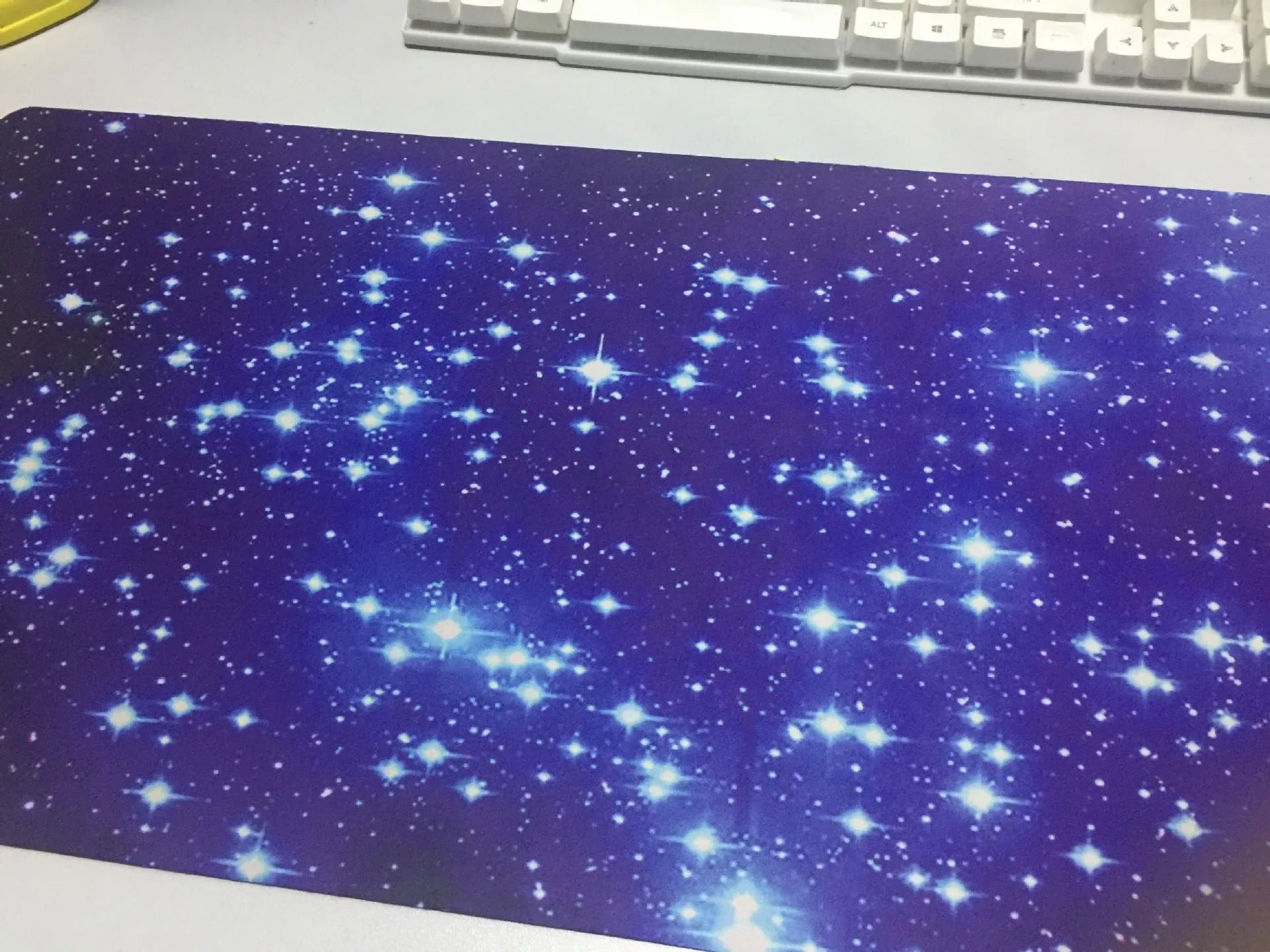 Blue star mouse pad with high-density fabric surface and anti-skid natural rubber base on a desk