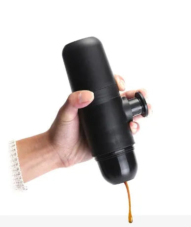 Black portable manual coffee machine measuring 6cm by 17.5cm on a table