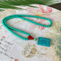 Hand-woven turquoise mesh flower lucky pendant on an adjustable ball bead necklace.