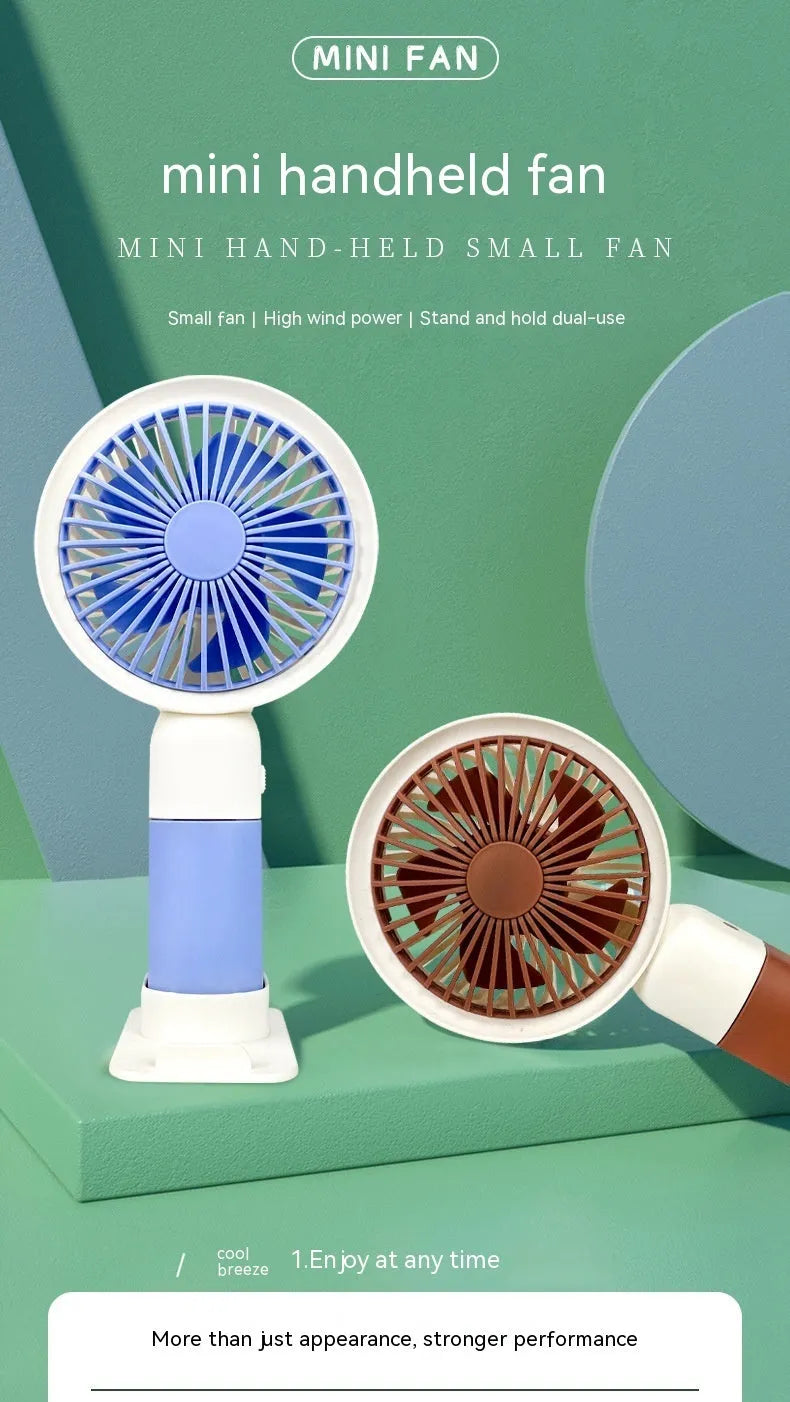 Handheld mini fan with phone holder, 16x8x6cm, five plastic blades, available in brown, pink, or blue.