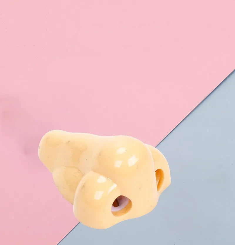 Flesh-coloured plastic student pencil sharpener with geometry design on a white background.