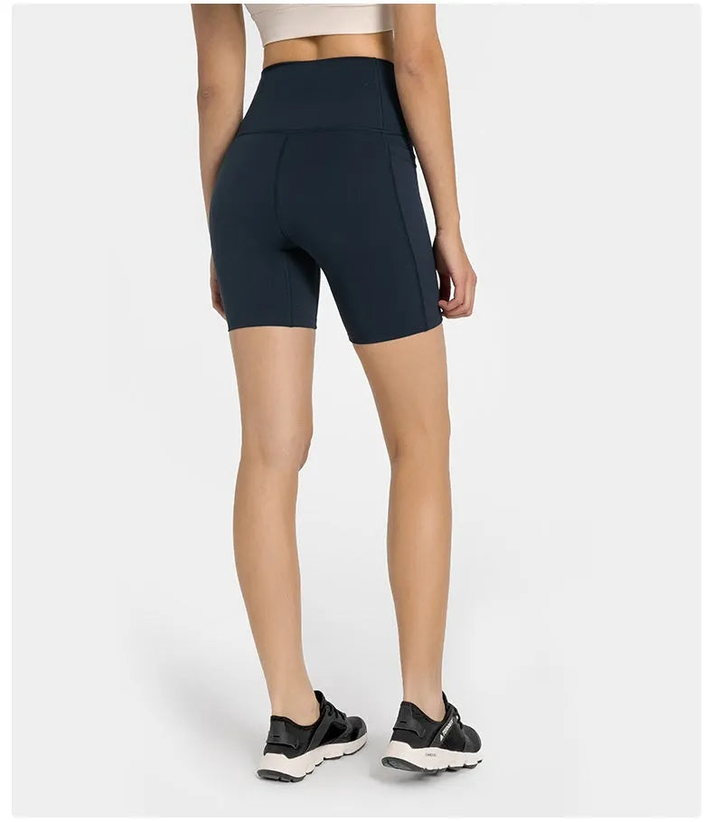 Women's solid colour mid-length sports shorts with a tight fit and waistband.