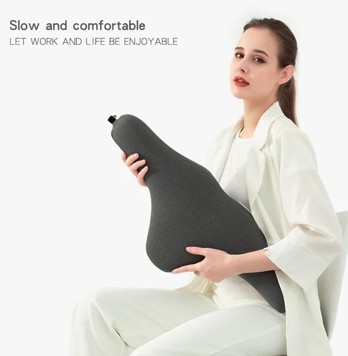 Dark grey memory foam car neck pillow on a car headrest.