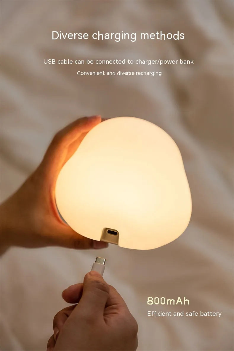 Cute duck-shaped silicone LED night lamp with touch sensor and warm glow on a bedside table