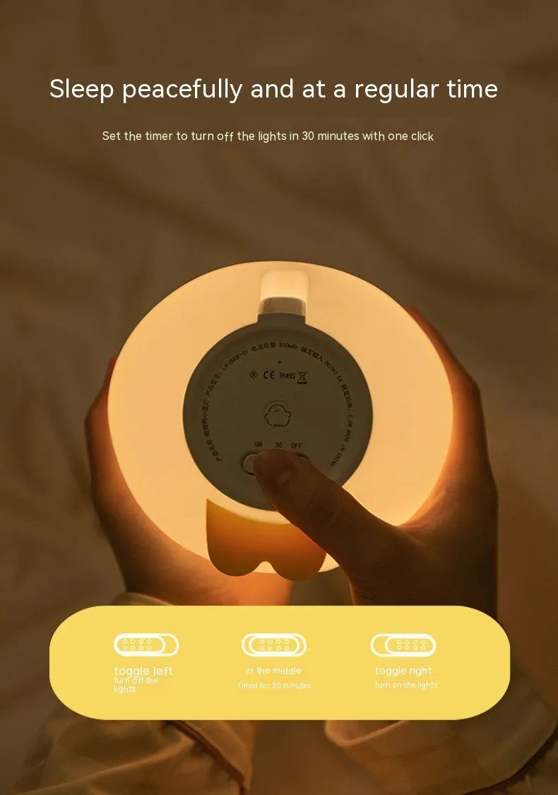 Cute duck-shaped silicone LED night lamp with touch sensor and warm glow on a bedside table