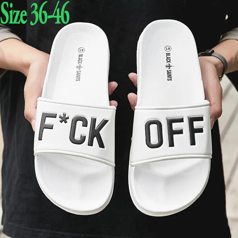 Men's black open-toe slipper with textured rubber sole, shown on a wooden floor.