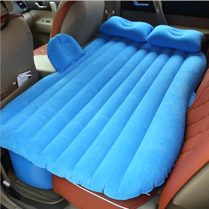 Black car inflatable bed with two pillows, shown inflated in a vehicle's rear compartment.