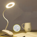 Modern clip-on rechargeable LED desk lamp with touch switch and plastic shade in use on a desk.