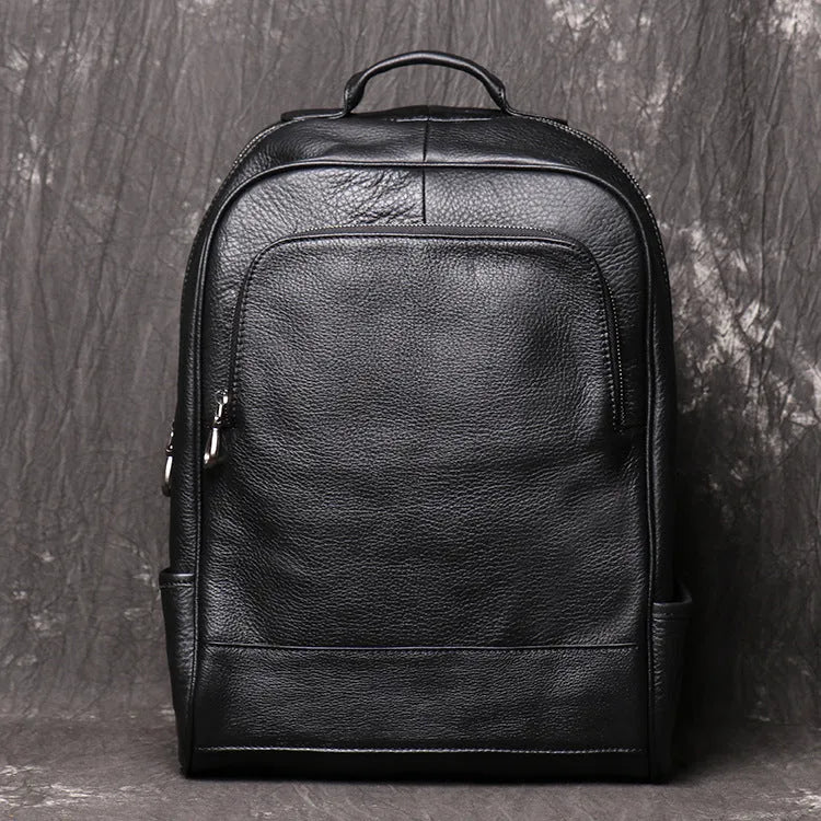 Men's black first layer cowhide leather travel backpack with multiple zipper pockets and top handles, 30cm by 42cm.