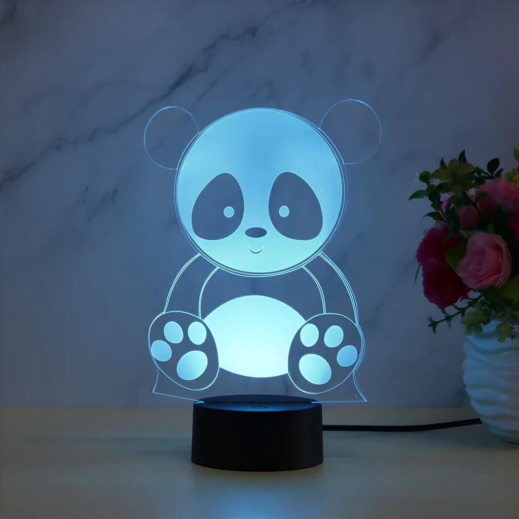 Panda-shaped acrylic night light with remote control on a table, showing multi-coloured LED illumination.