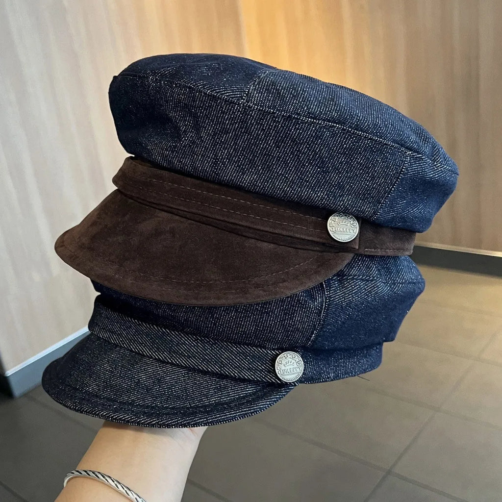 Dark blue denim octagonal newsboy flat cap with an adjustable strap, shown with a contrasting brown brim.