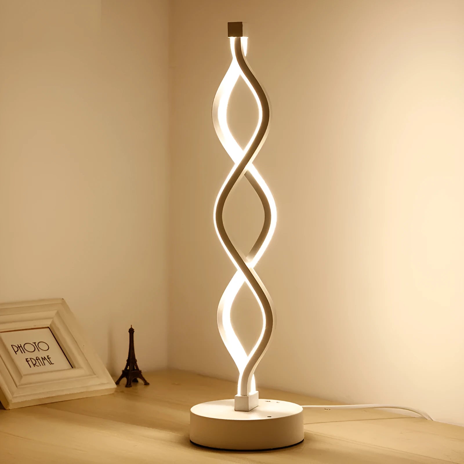 Modern LED desk lamp with aluminium metal body and acrylic mask, gold colour, on a desk