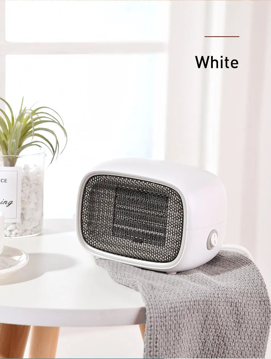Green mini portable heater with dimensions 158mm x 90mm x 114mm on a wooden desk.