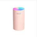 Pink USB desktop humidifier with LED lights and water tank on wooden desk