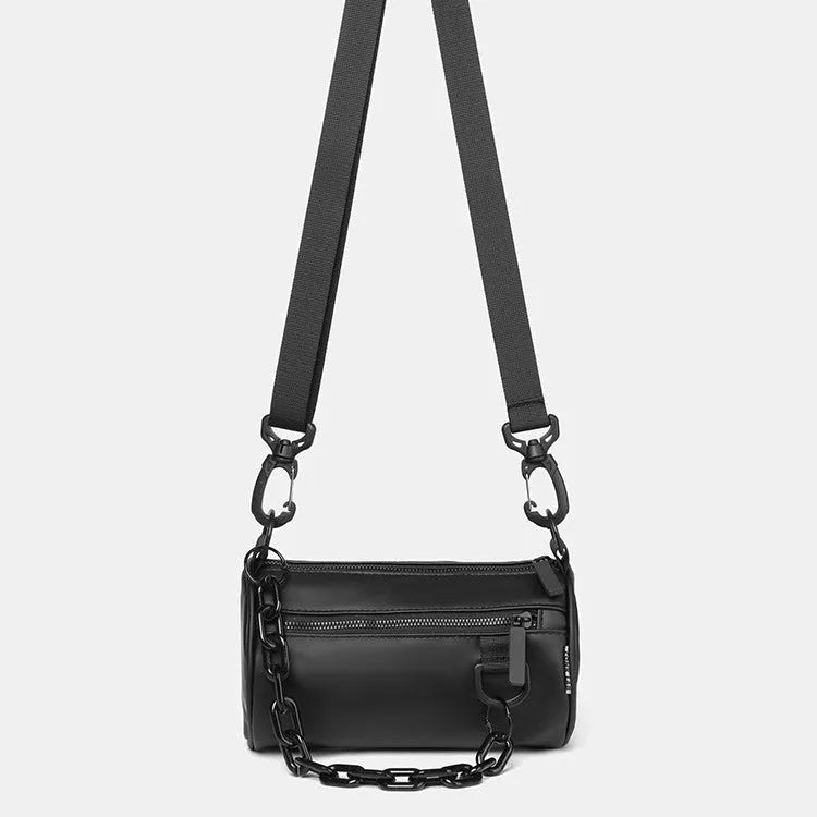 Black Oxford cloth messenger bag with a chain detail, worn crossbody.