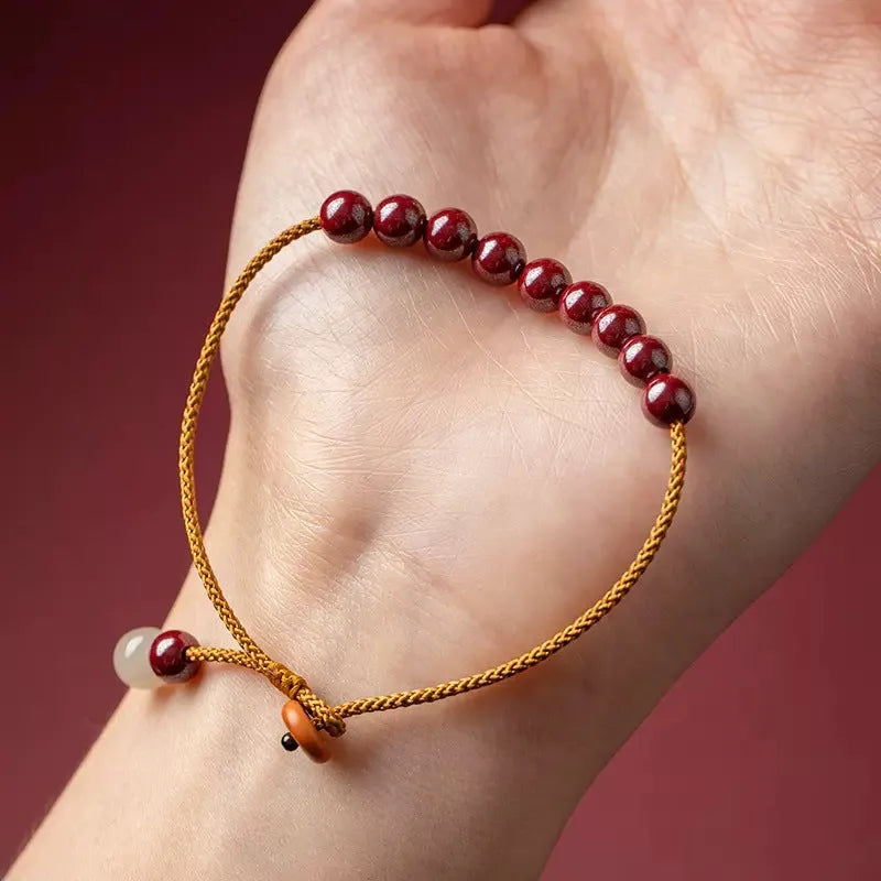 Hand-woven cinnabar bracelet with geometric design showing natural mineral colours
