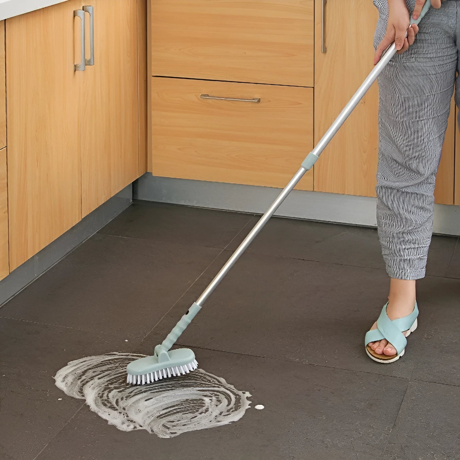 Blue long handle floor brush with telescopic aluminium rod and detachable nylon bristle head on tiled floor