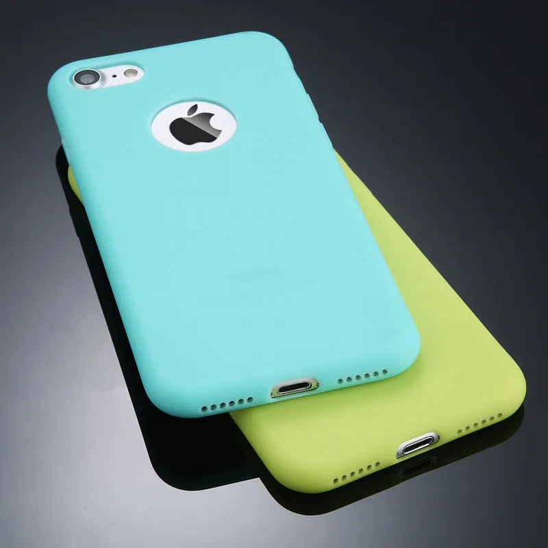 Soft plain silicone TPU phone case for iPhone in candy colours like pink, blue, and green on a table.