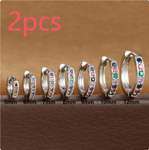 Circle-shaped cubic zirconia stud earrings in gold, rose gold, and silver colours on a white background.