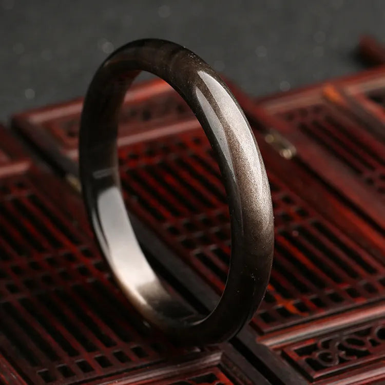 Natural silver stone cat's eye bracelet in national style with geometric design on a wrist.