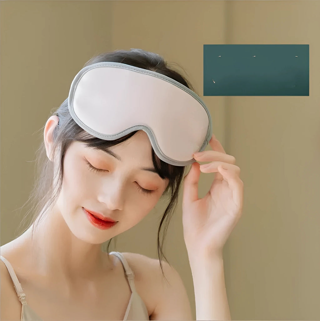 Pink portable eye steam massage goggles with USB cable on a grey background.