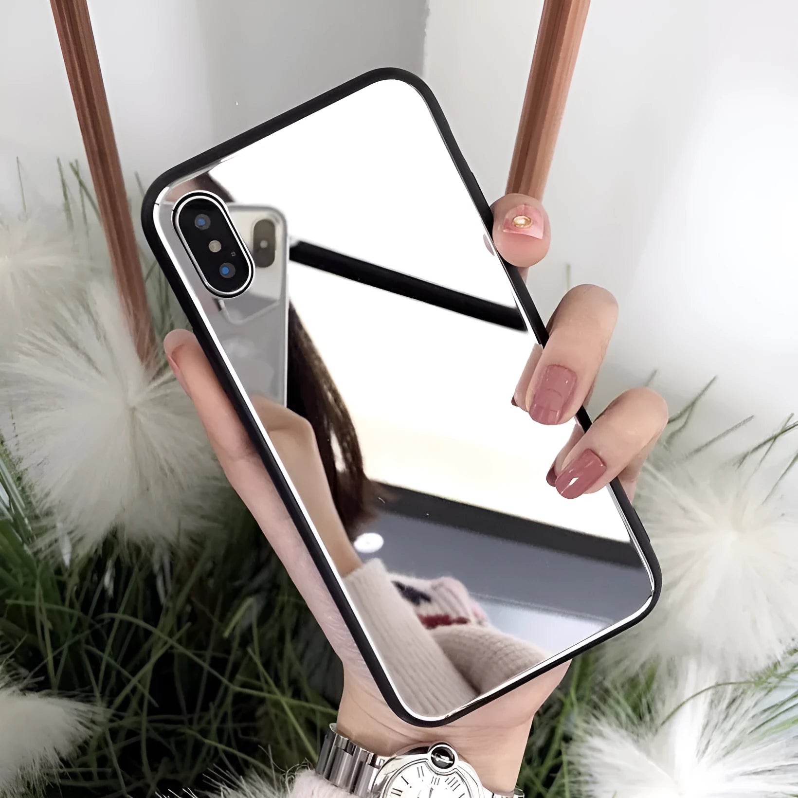 Black iPhone case with a reflective mirror panel on the back, shown fitted to an iPhone.