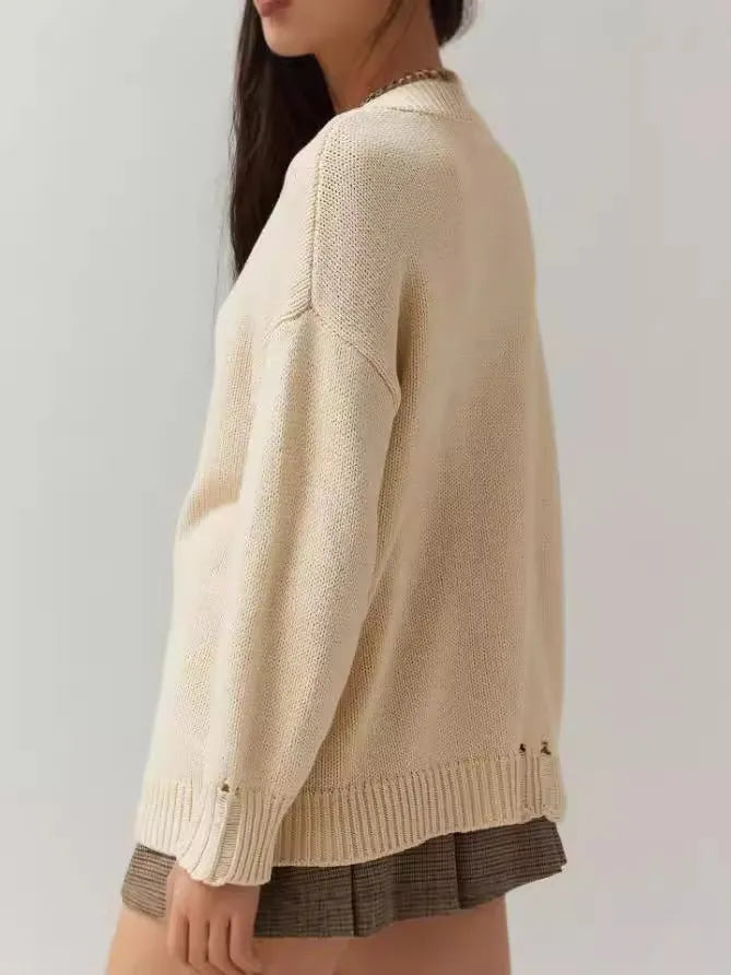 Beige women's loose-fitting acrylic jacquard knit sweater with round neck and long sleeves.