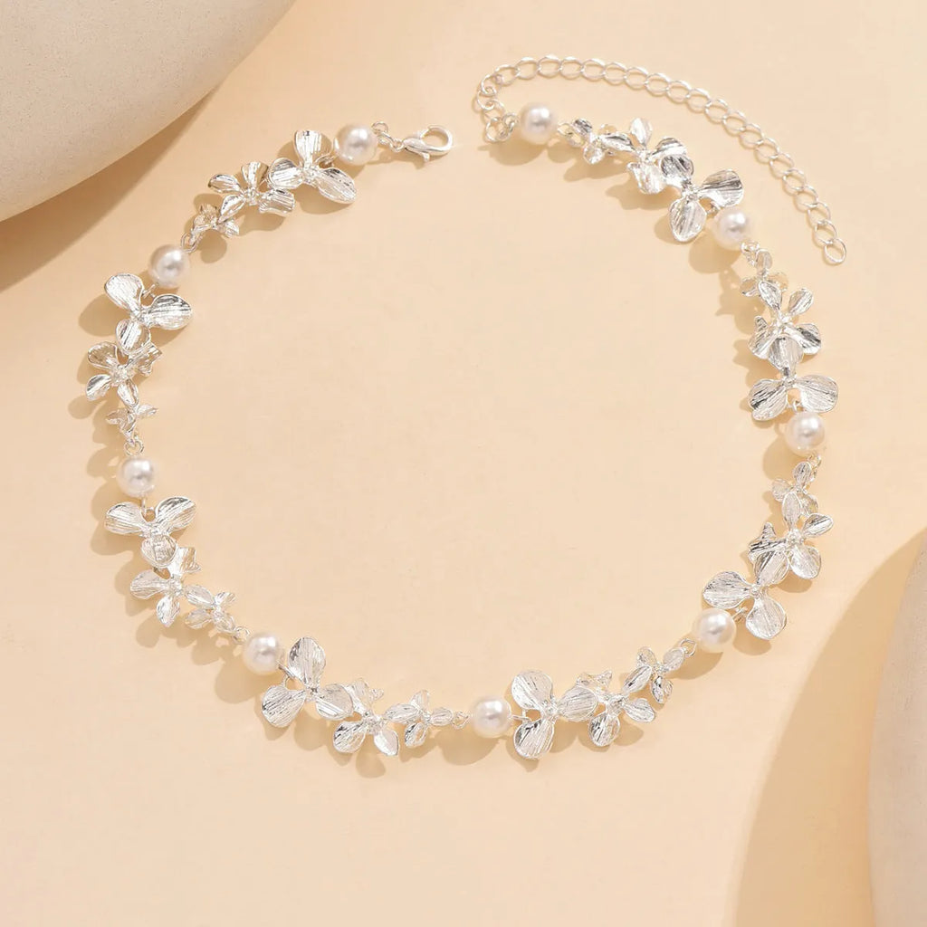 Bright silver alloy flower pearl curved needle clavicle necklace on neutral background
