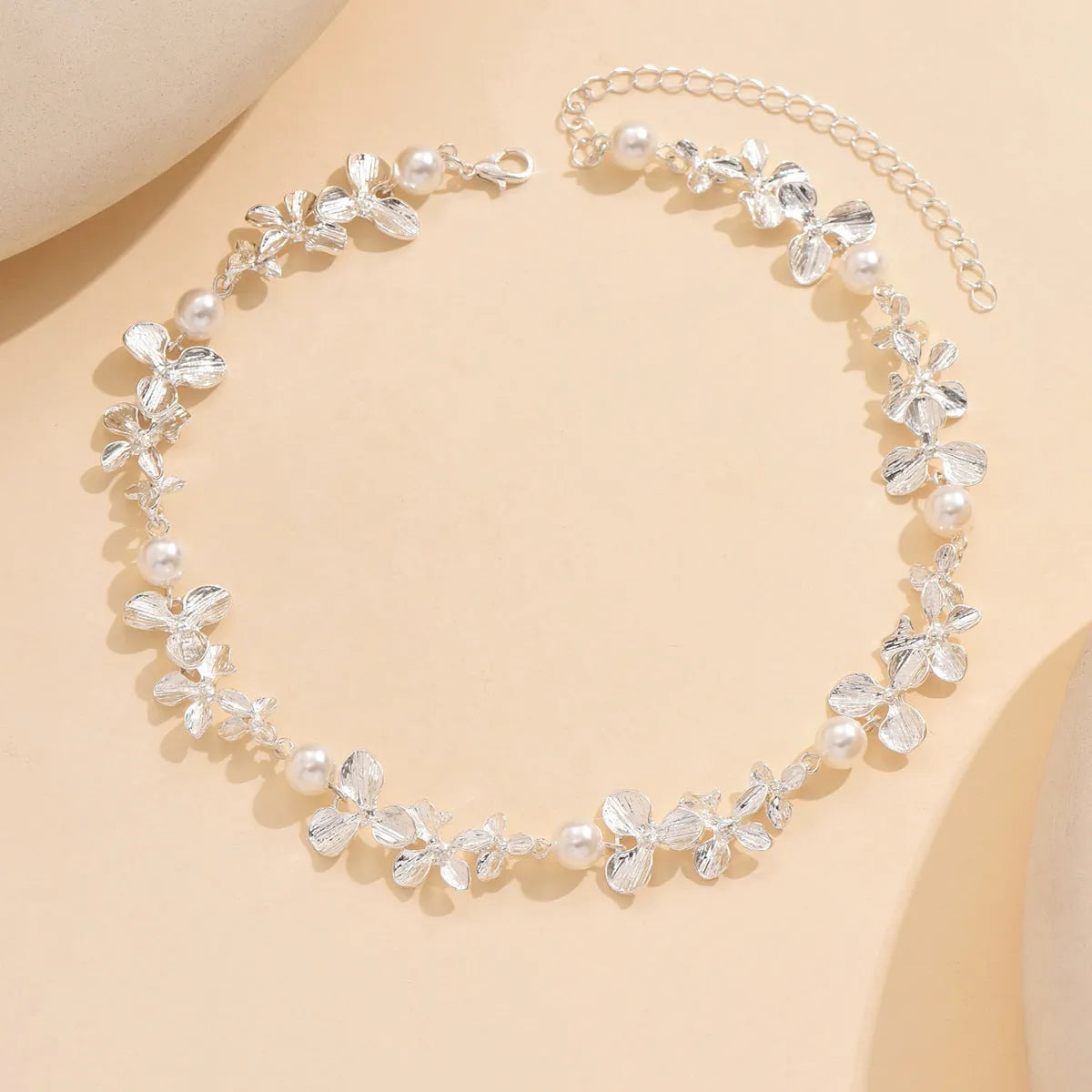 Bright silver alloy flower pearl curved needle clavicle necklace on neutral background
