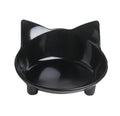 Shallow black and white melamine pet bowls with non-slip rubber bases on a kitchen floor.
