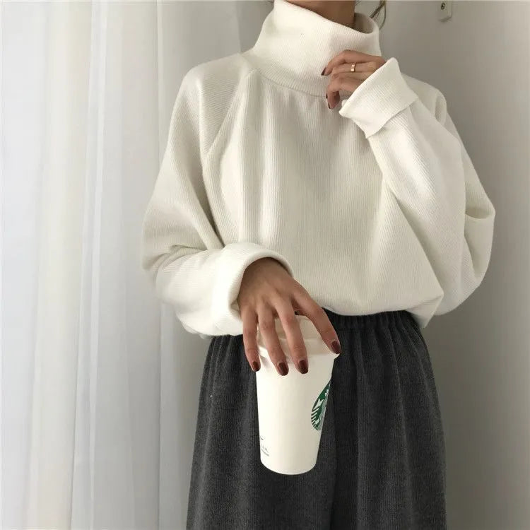 Women's apricot coloured half-high collar long sleeve loose fit top on a hanger