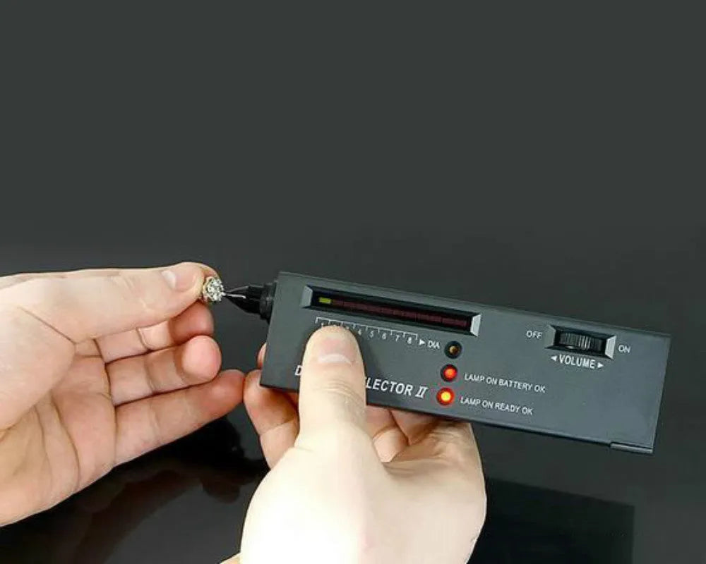 Black handheld diamond thermal conductivity meter with metal probe on a white background.