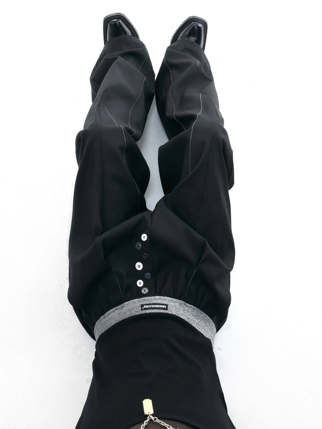 Drooping straight suit pants in black or grey with a high waist and button-open line detail.
