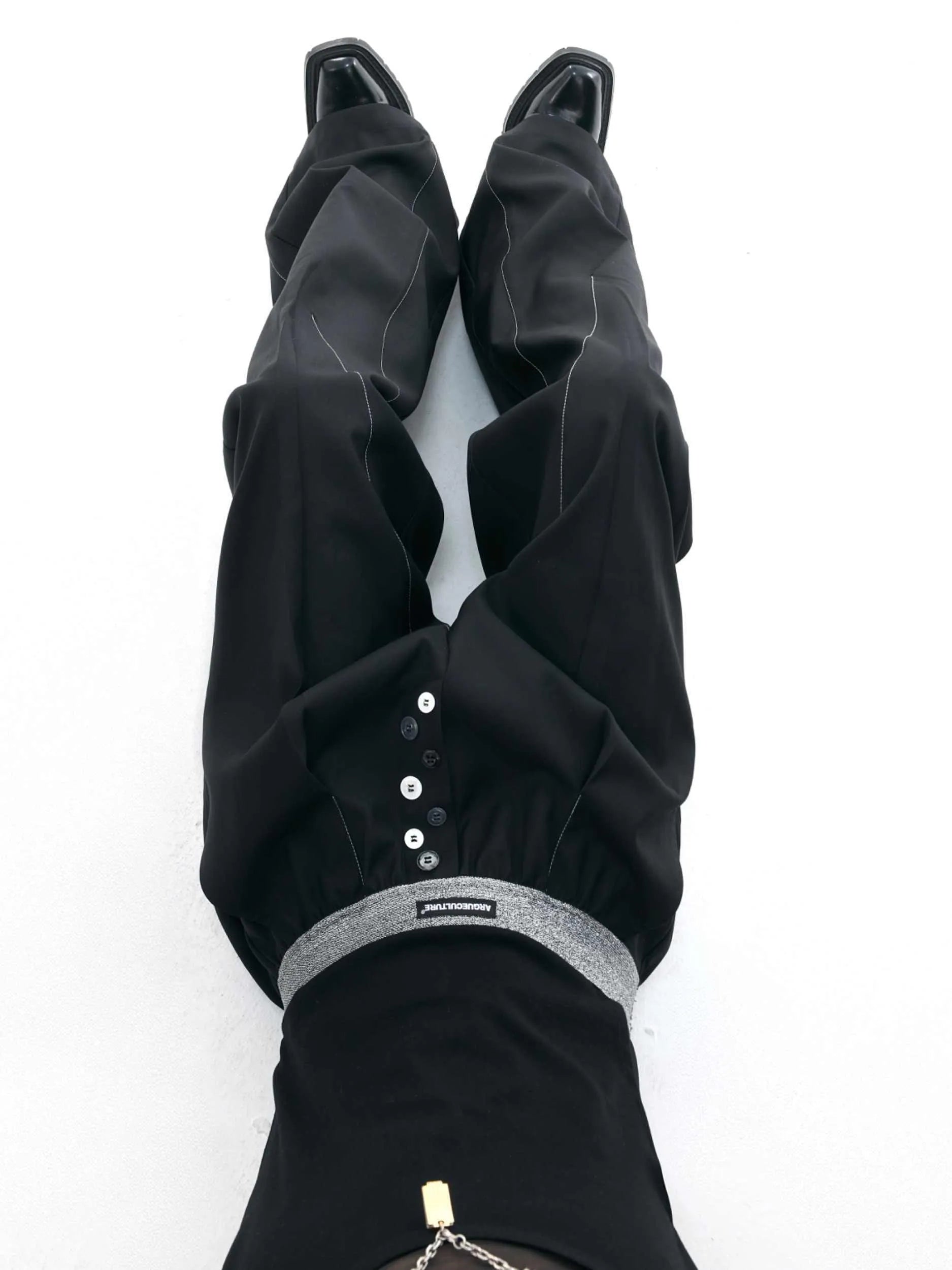 Drooping straight suit pants in black or grey with a high waist and button-open line detail.