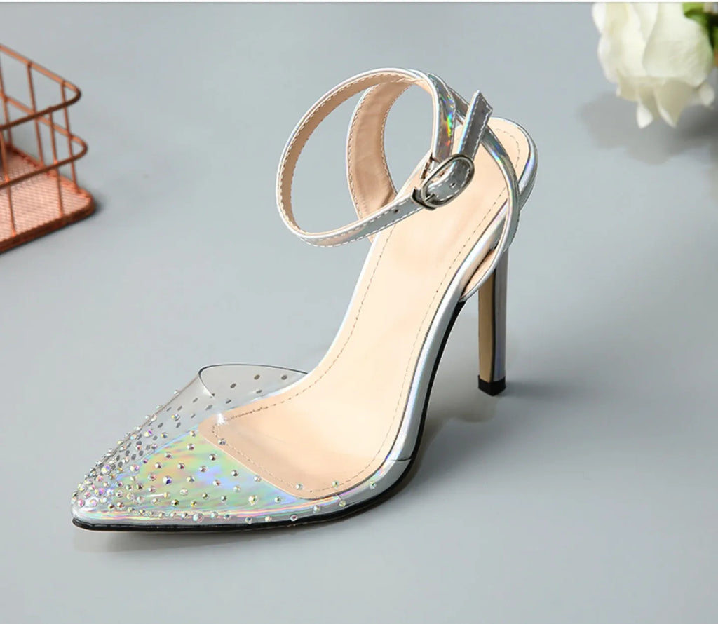 Women's pointed toe stiletto sandals with a diamond embellishment on the PVC upper and an adjustable ankle strap.