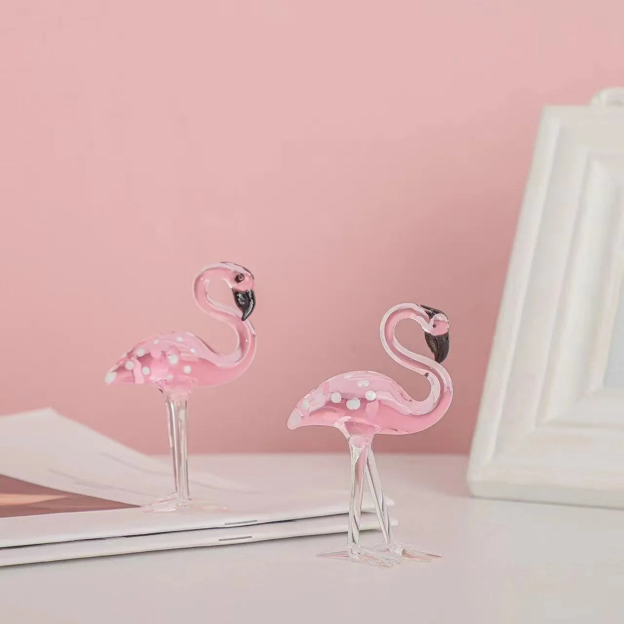 Pink flamingo decorative ornament made of white crystal on a table.