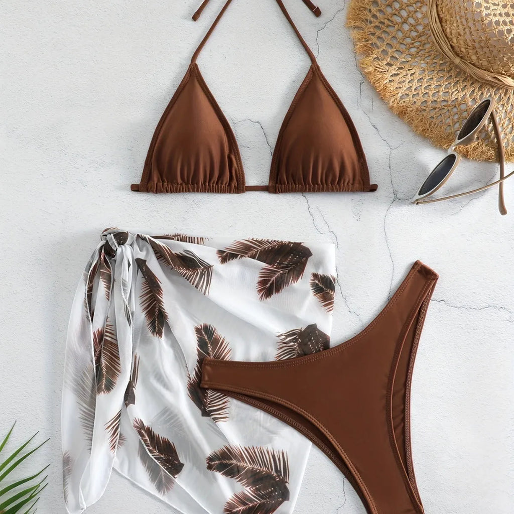 Women's orange polyester bikini set with a matching printed gauze skirt laid flat.