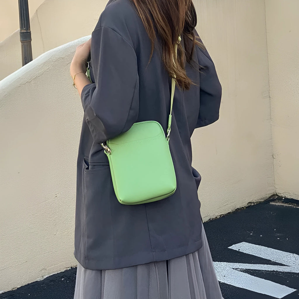Solid colour PU leather crossbody shoulder bag for women with adjustable strap.
