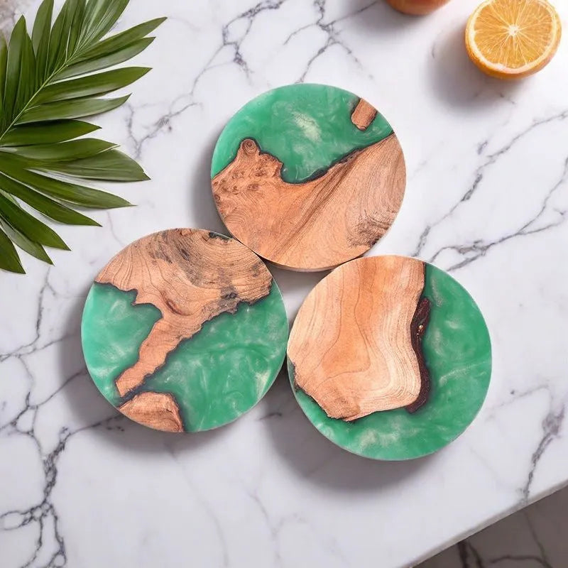 A solid black round resin coaster for a tea set, 9.8cm across and 1cm thick, on a wooden surface.