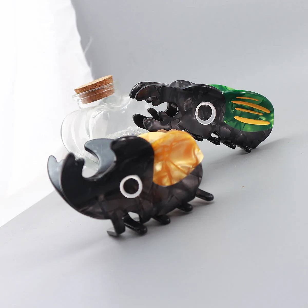 Handmade green cartoon beetle grip made from cellulose acetate sheet holding papers.