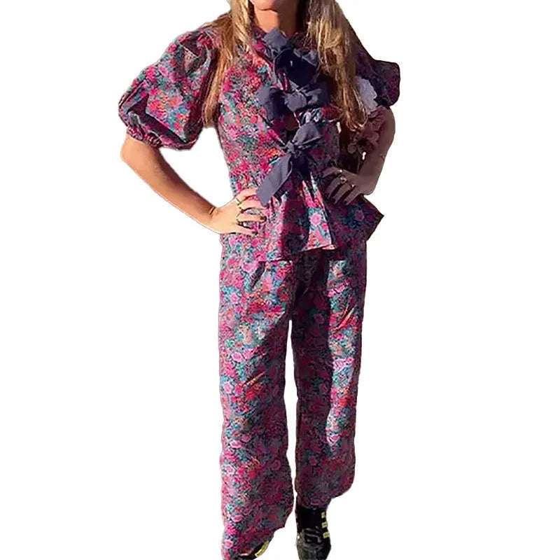 Women's floral print polyester trousers suit with puff sleeve top and matching trousers.