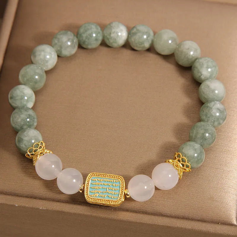 Close-up of a women's oil green emerald crystal bracelet featuring a five-piece sutra design.